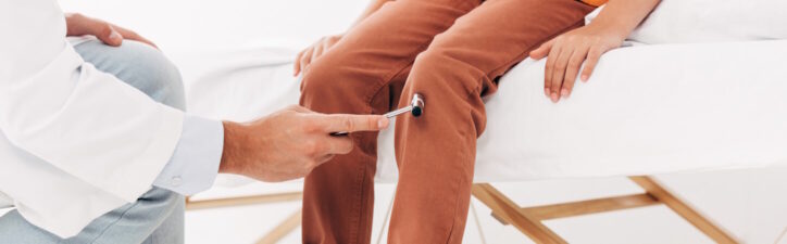 panoramic shot of pediatrist examining kid with reflex hammer