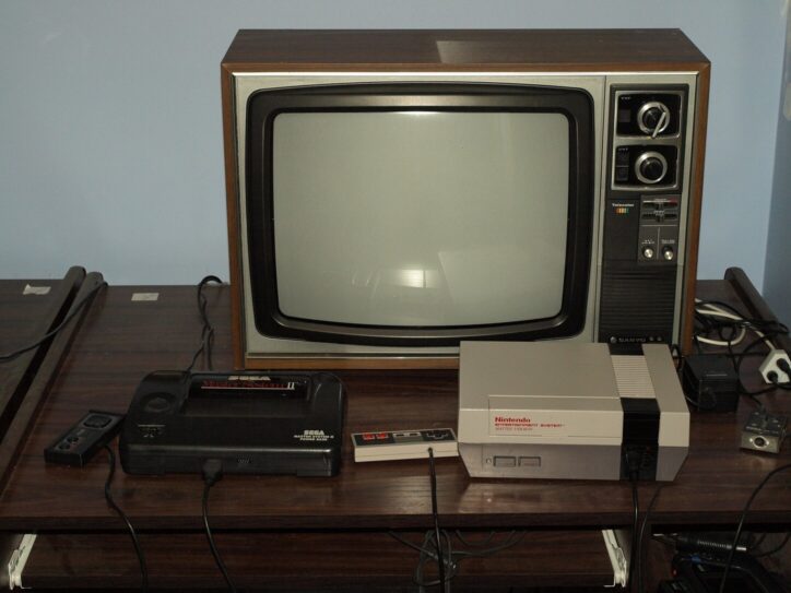 Photo of an old television next to game consoles